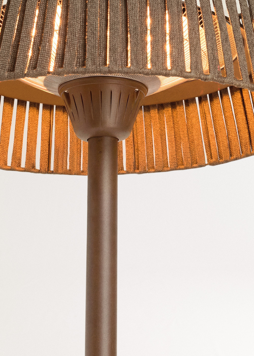 Un calentador de patio marrón con pantalla tejida y interior iluminado.