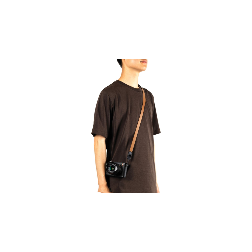 Man draagt bruin T-shirt en camera met bruine riem.