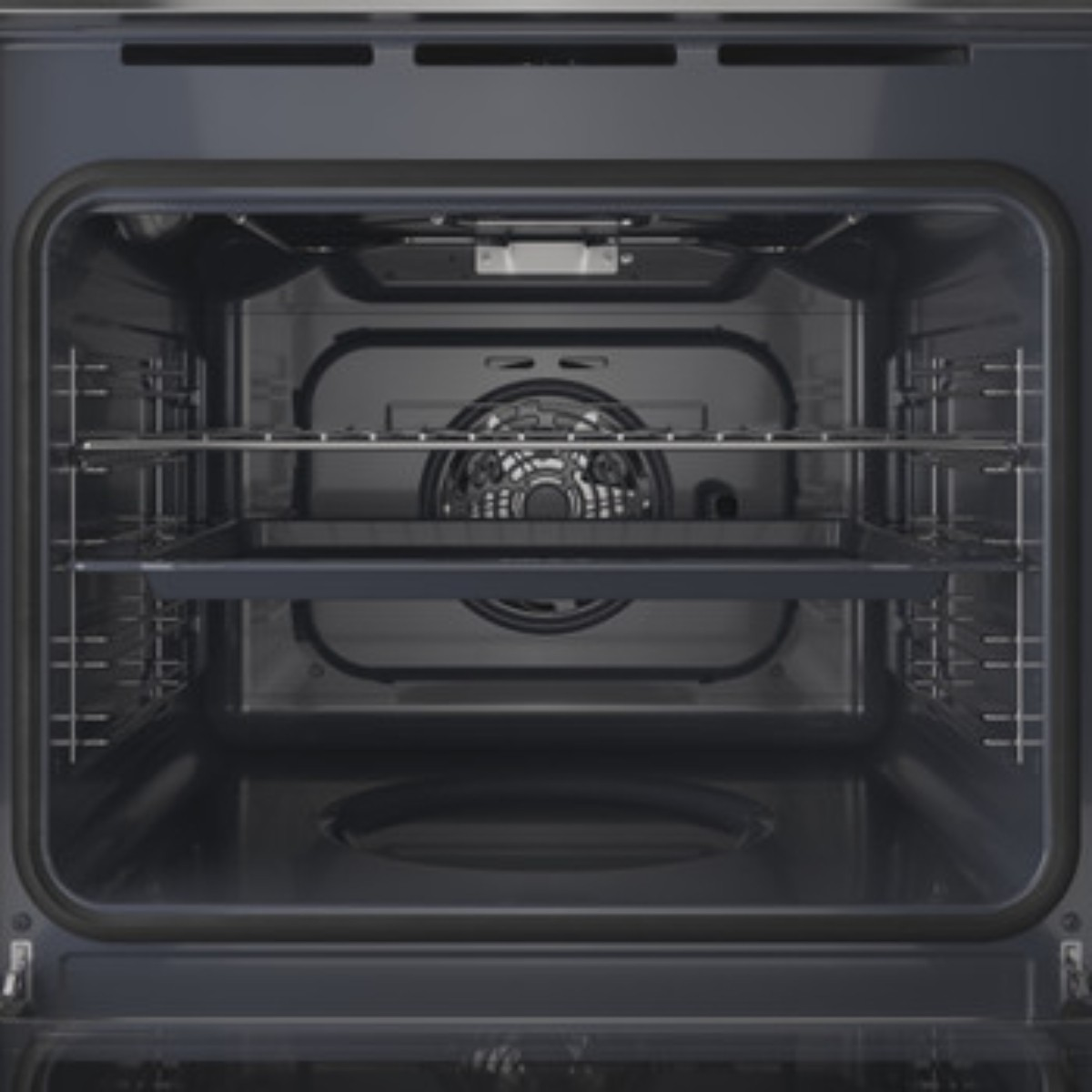 Vista interna di un forno pulito e vuoto con due griglie e una teglia.