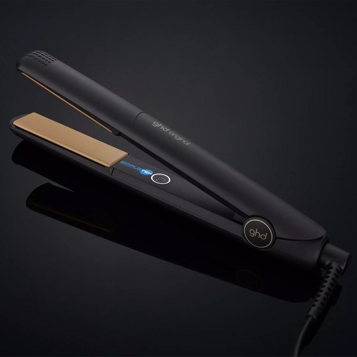 Una piastra per capelli GHD nera con piastre dorate su sfondo nero.