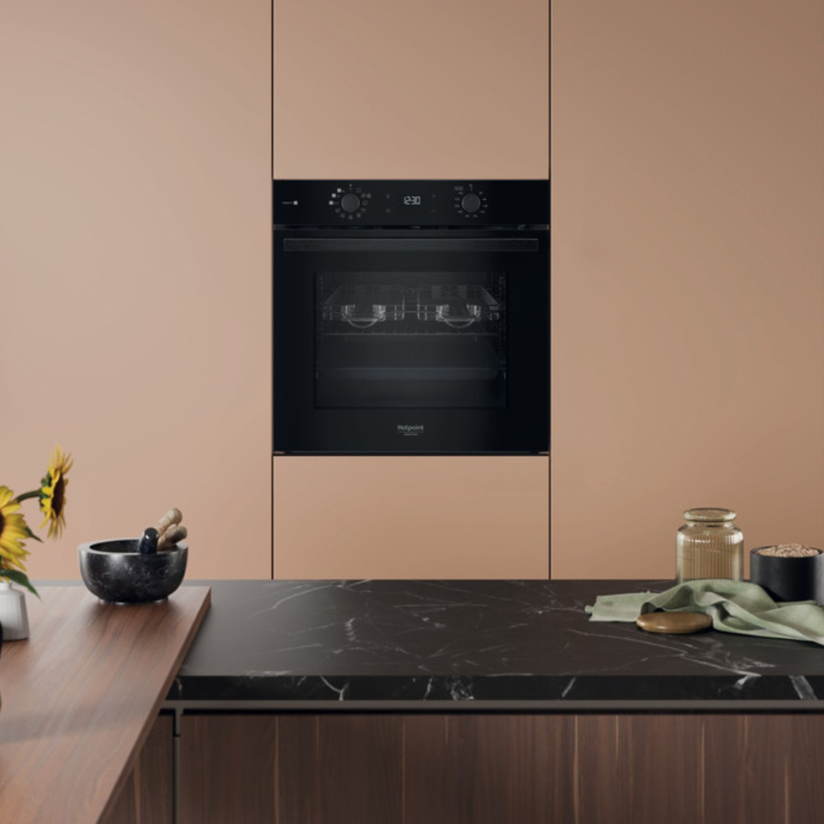 Una cucina moderna con forno da incasso, piano di lavoro in marmo e utensili.