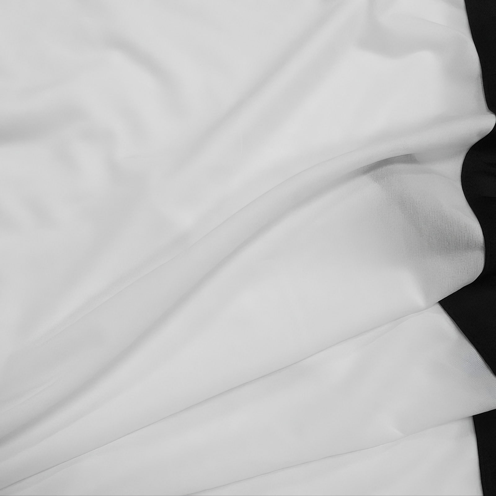 Tela blanca drapeada con borde negro.