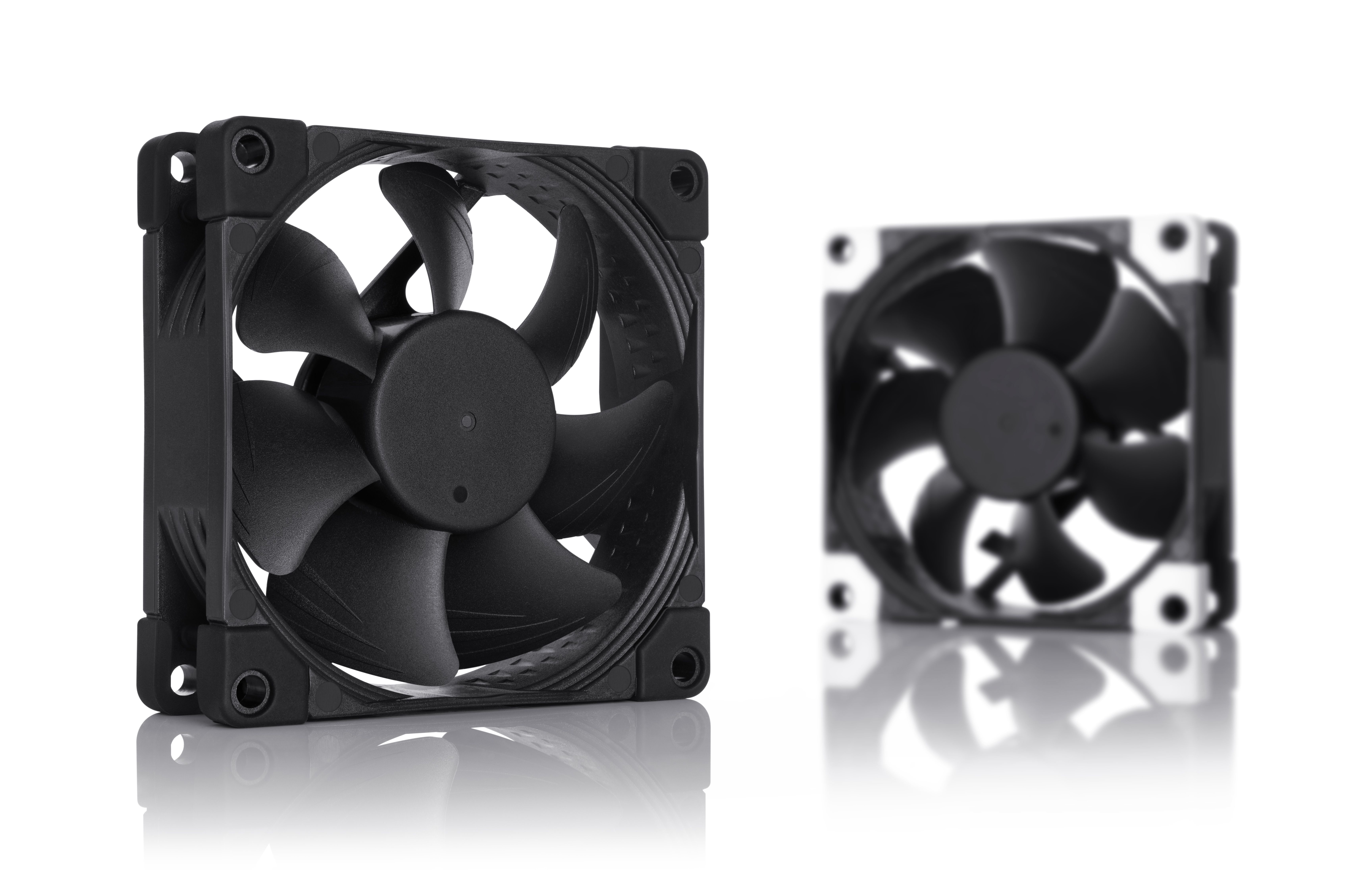 Two black computer fans on a white background, one in focus, the other blurred.