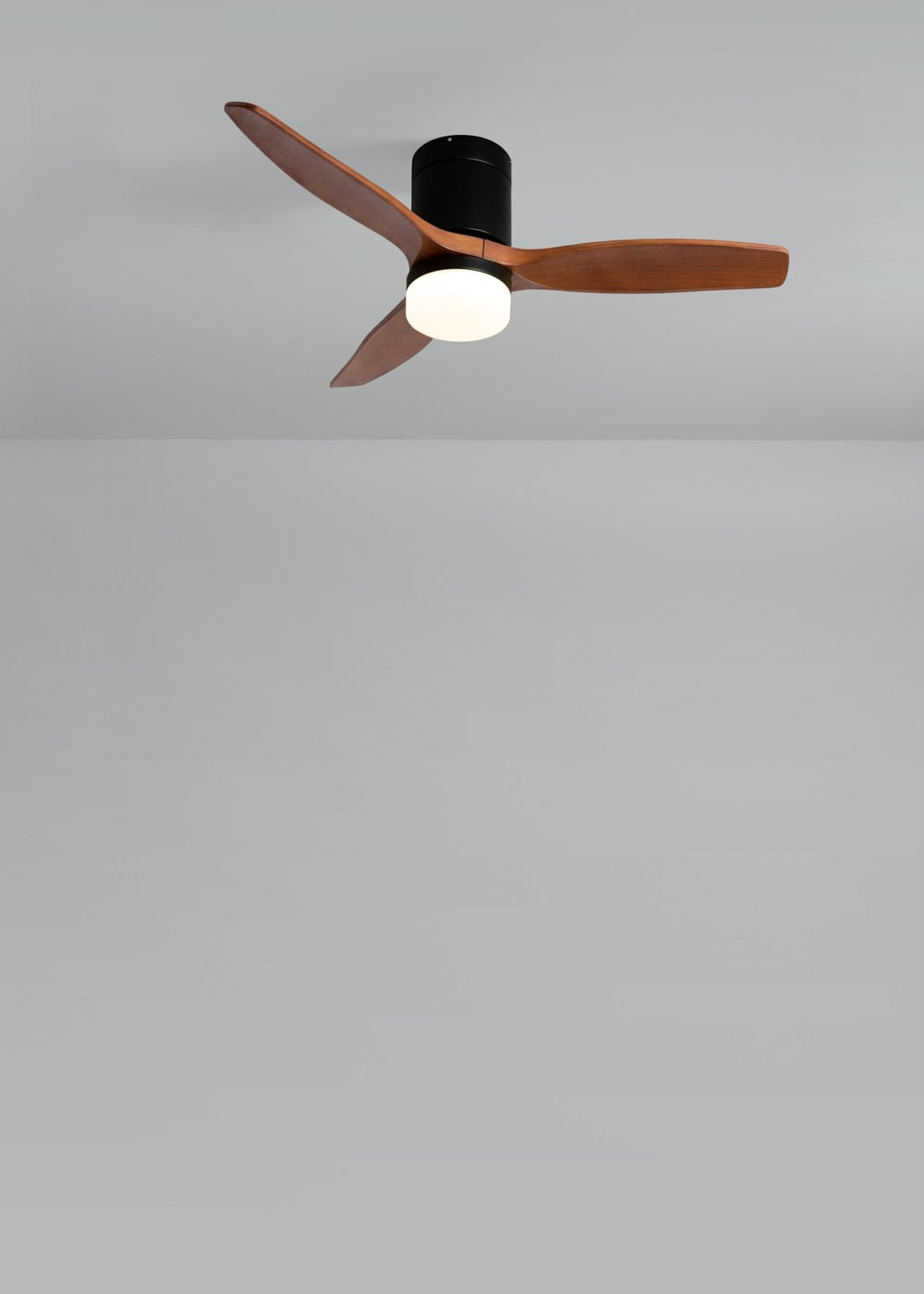 Un ventilador de techo moderno con tres aspas de madera y luz integrada.