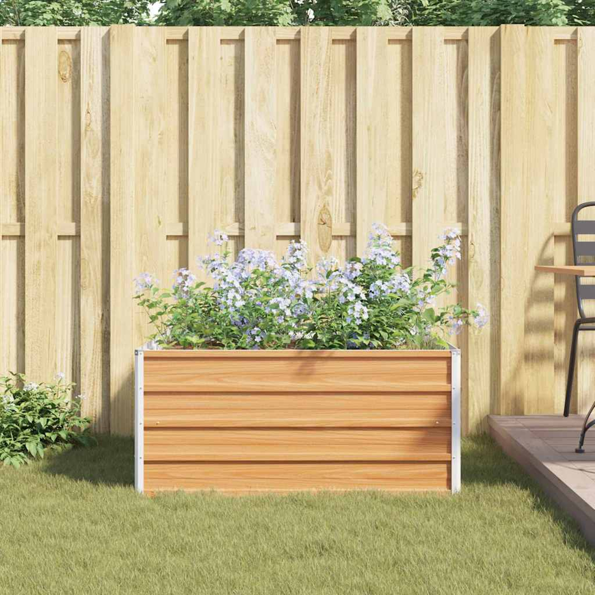 Una fioriera in legno con fiori viola chiaro si trova sull'erba verde davanti a una recinzione di legno.