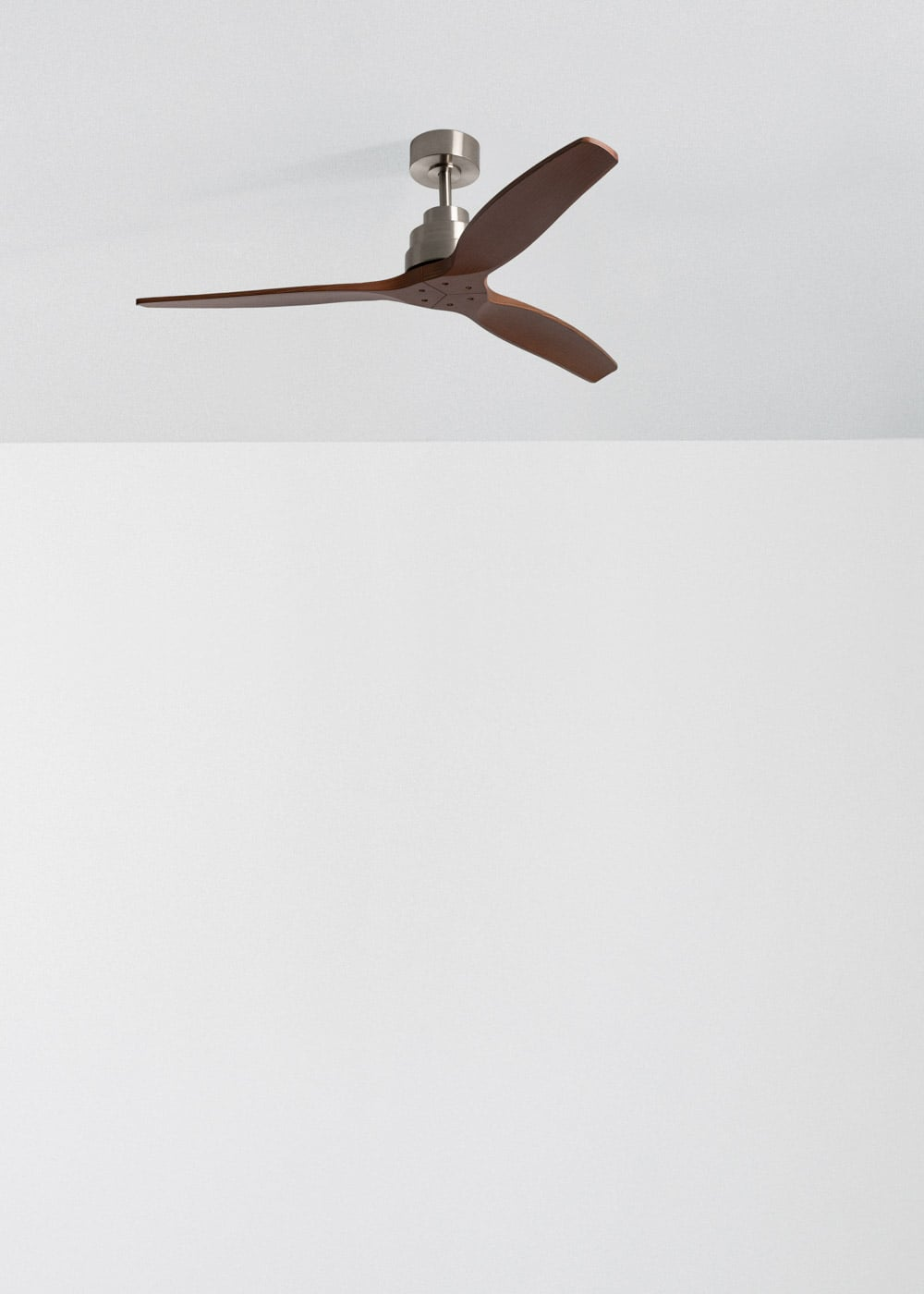 Ventilador de techo moderno con tres aspas de madera y cuerpo de metal cepillado.