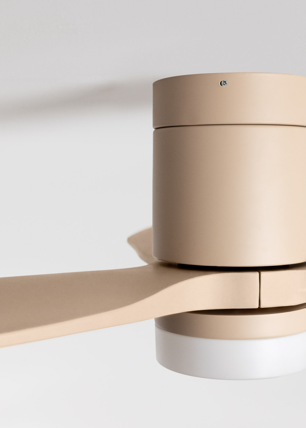Un ventilador de techo beige con luz, primer plano de las aspas y la carcasa.