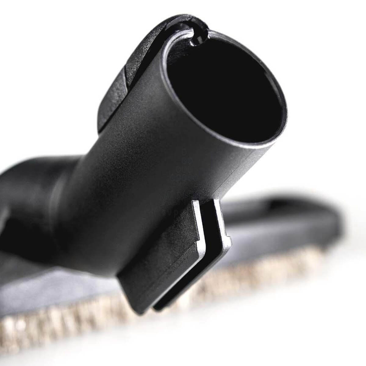 Gros plan d'une buse d'aspirateur noire avec des poils.