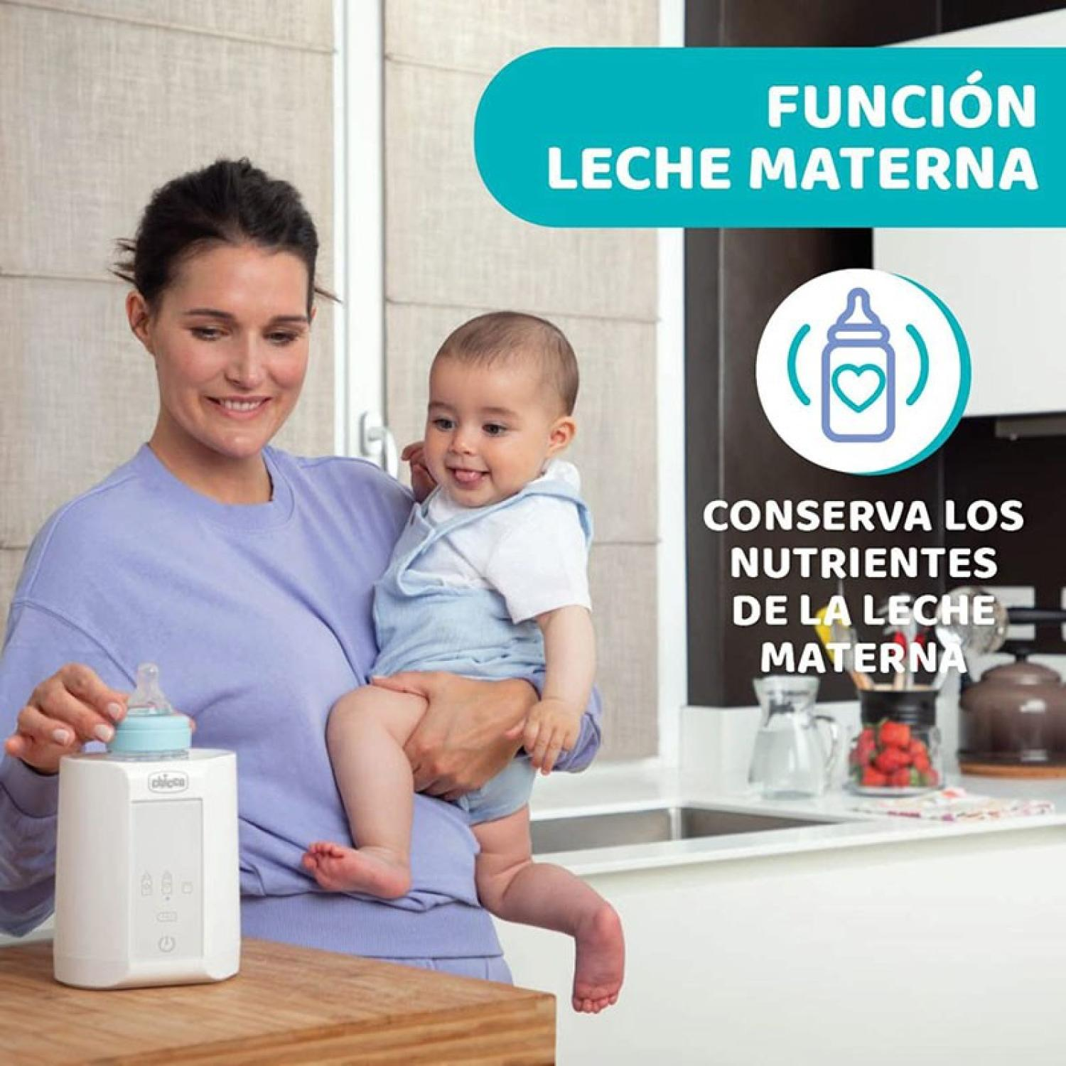 Eine Frau hält ein Baby und einen Flaschenwärmer in einer Küche.