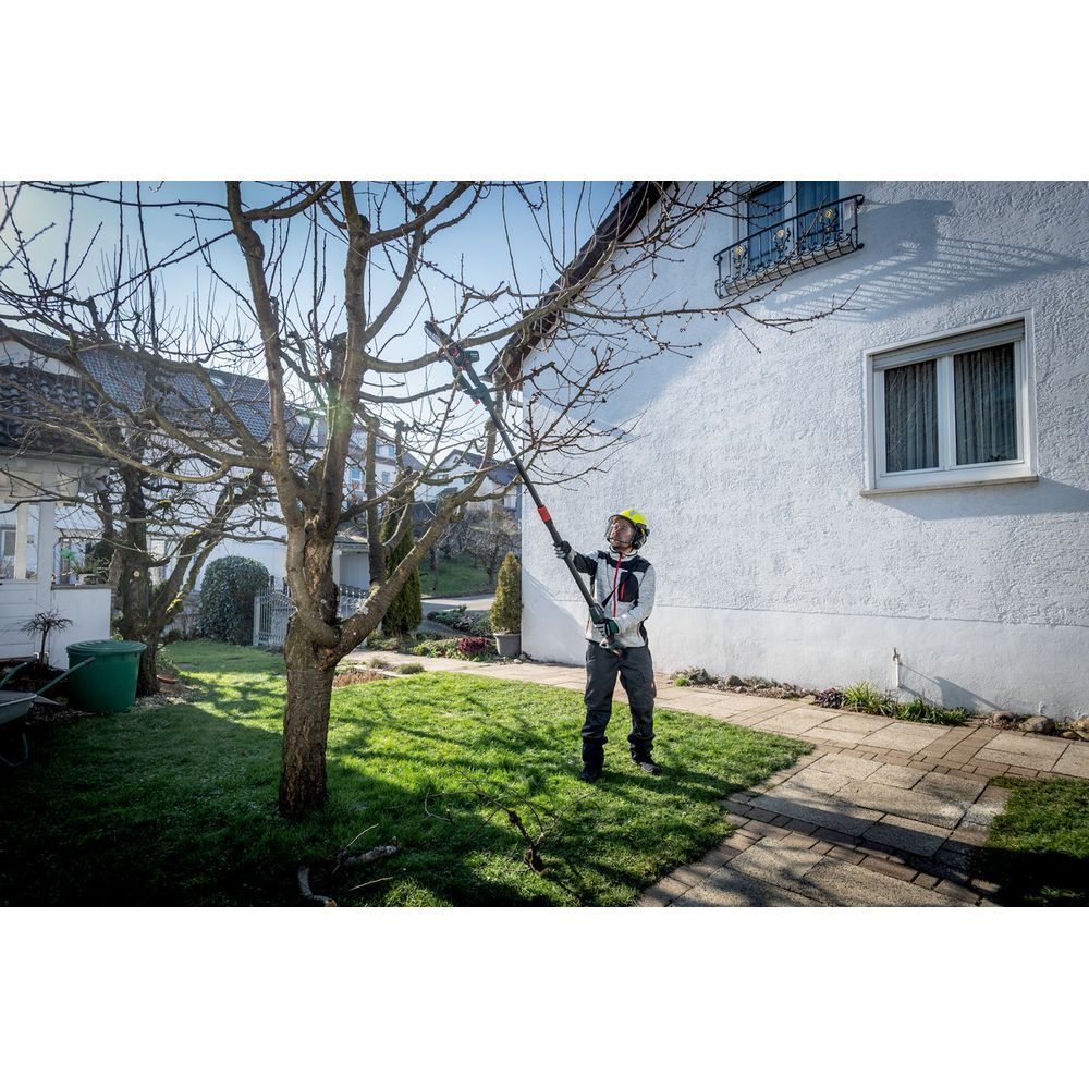 Homme casqué élaguant un arbre avec un taille-haie sur perche.