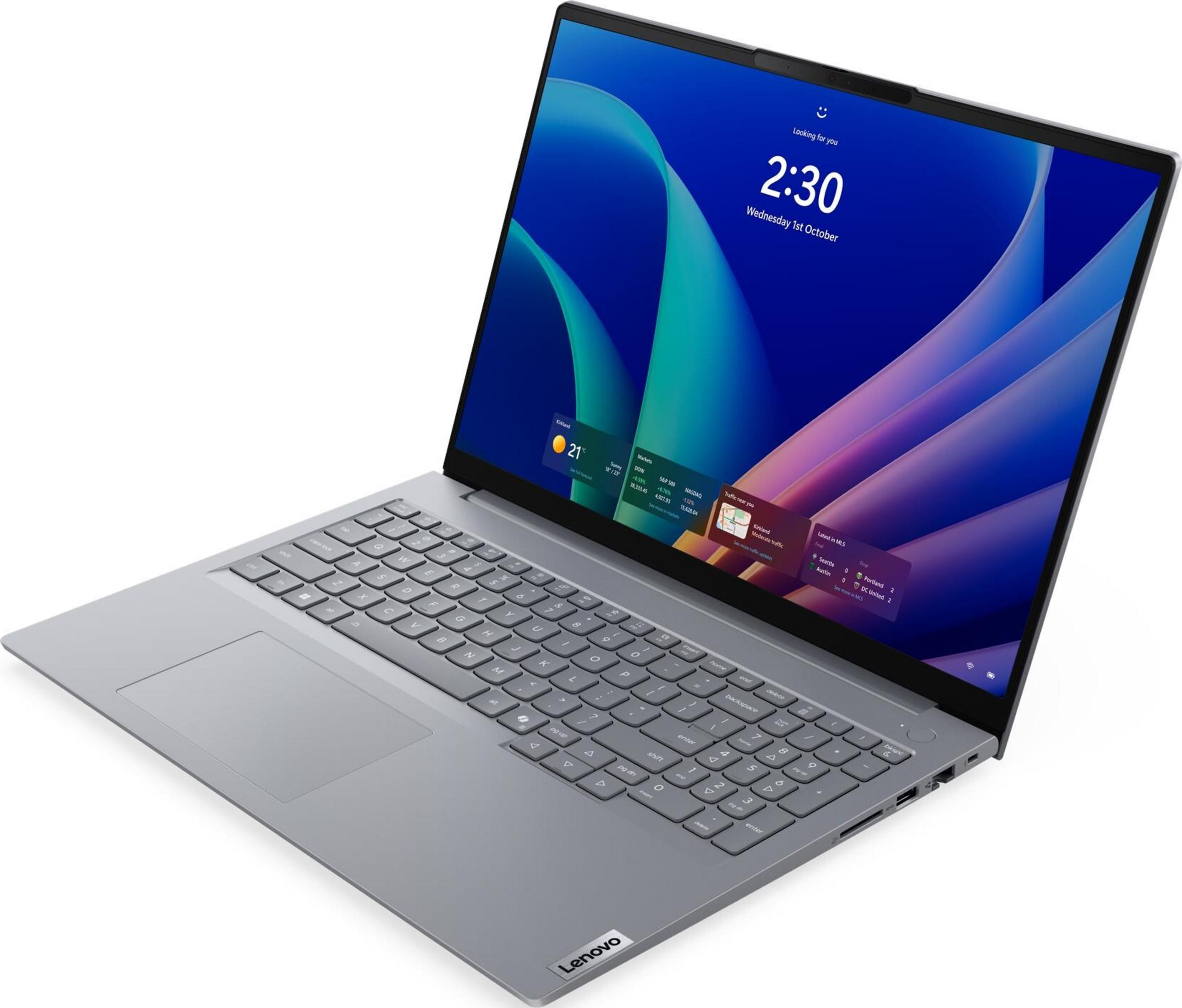 Grauer Laptop mit beleuchtetem Bildschirm, der das Windows-Anmeldebild zeigt.