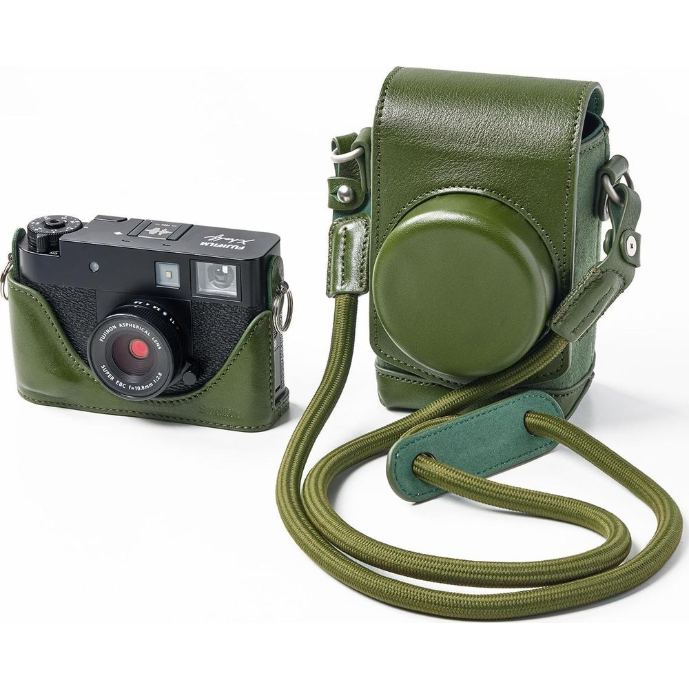Een zwarte camera in een groene leren hoes naast een groene cameratas met riem.