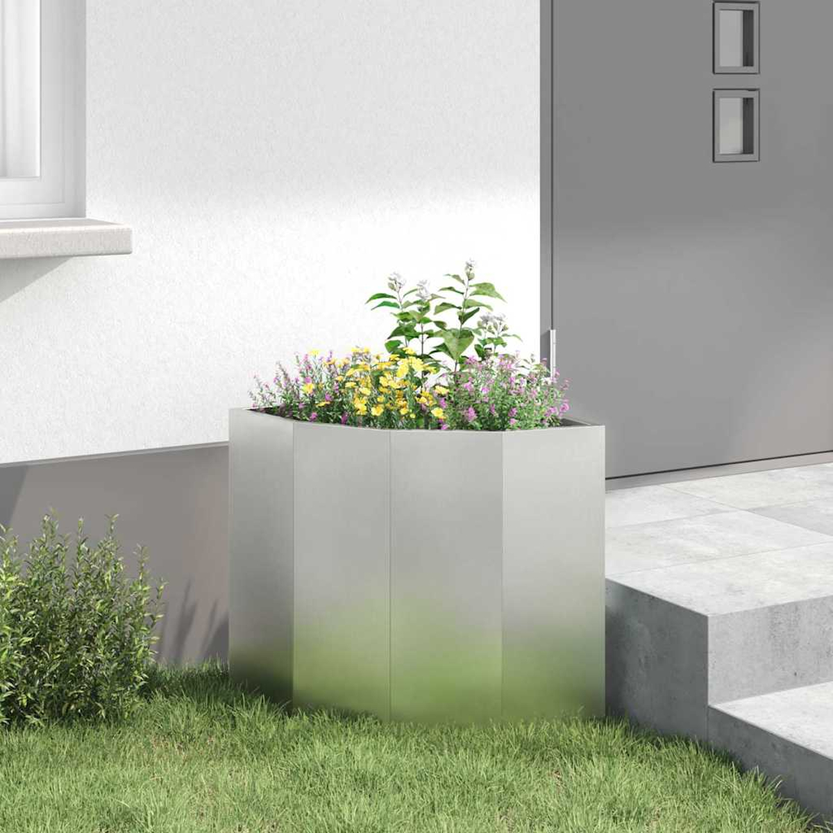 Fioriera moderna in metallo con fiori colorati davanti a una porta.