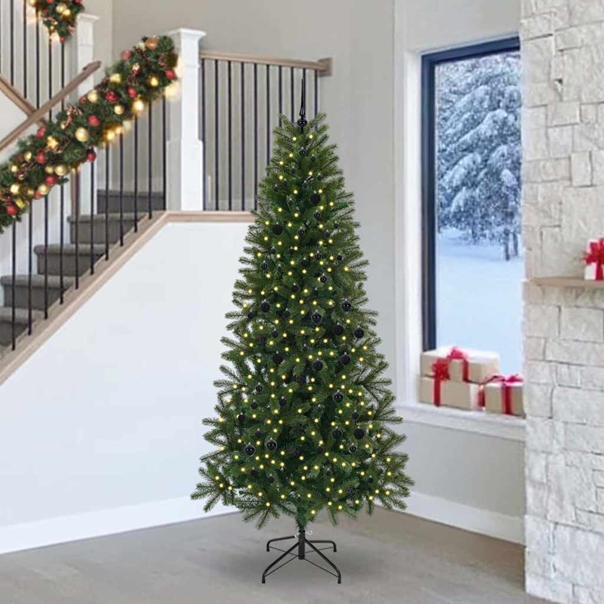 Un albero di Natale decorato con luci e palline nere si trova accanto a una scala.