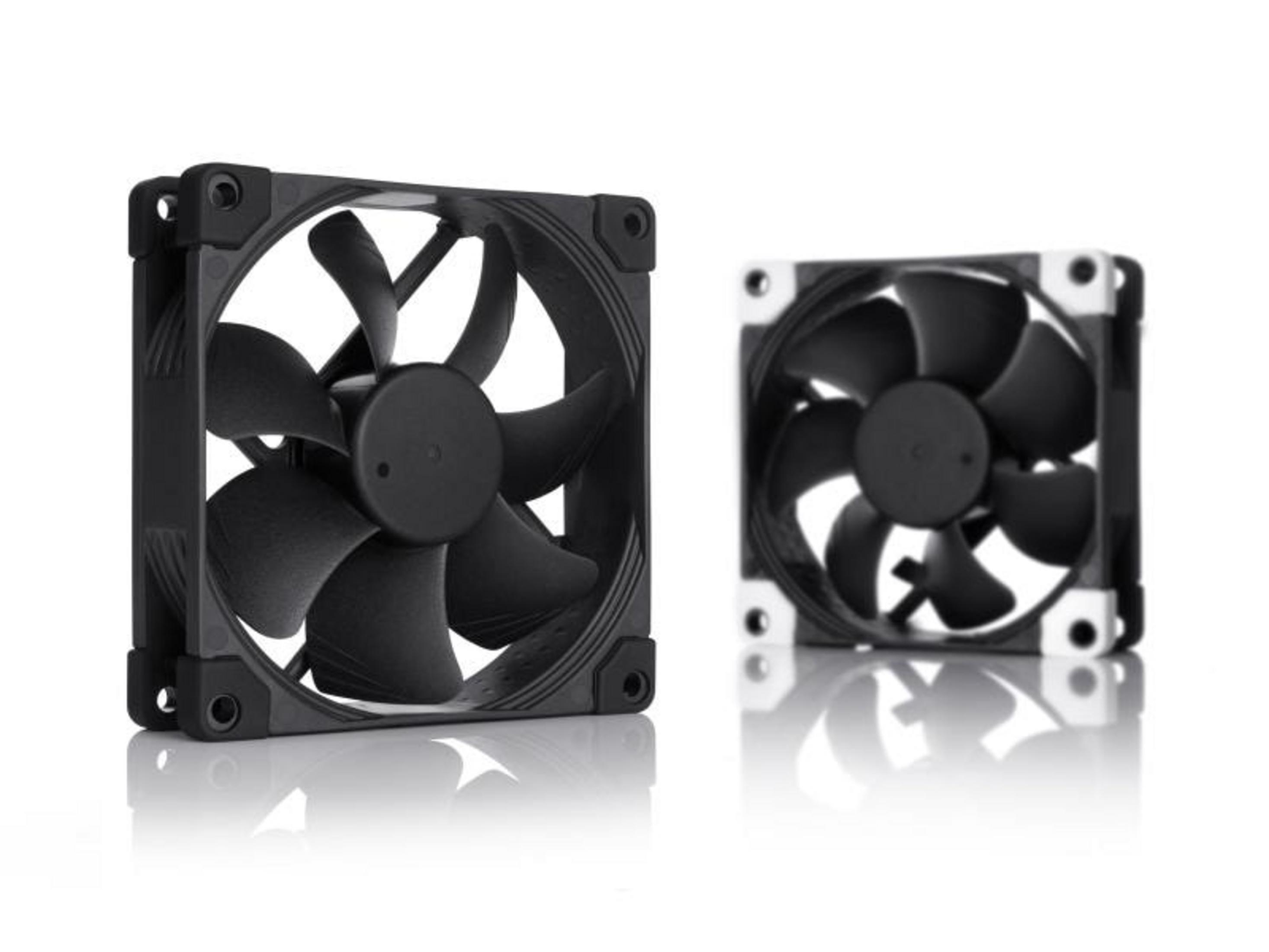 Two black computer fans on a white reflective surface.