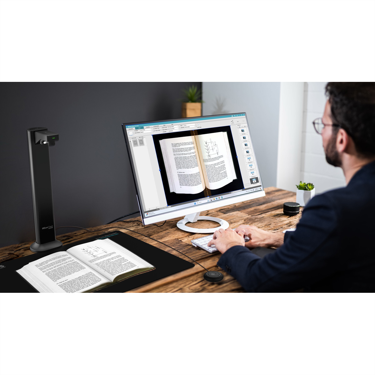 Homme utilisant un scanner de documents pour numériser un livre ouvert sur un bureau en bois.