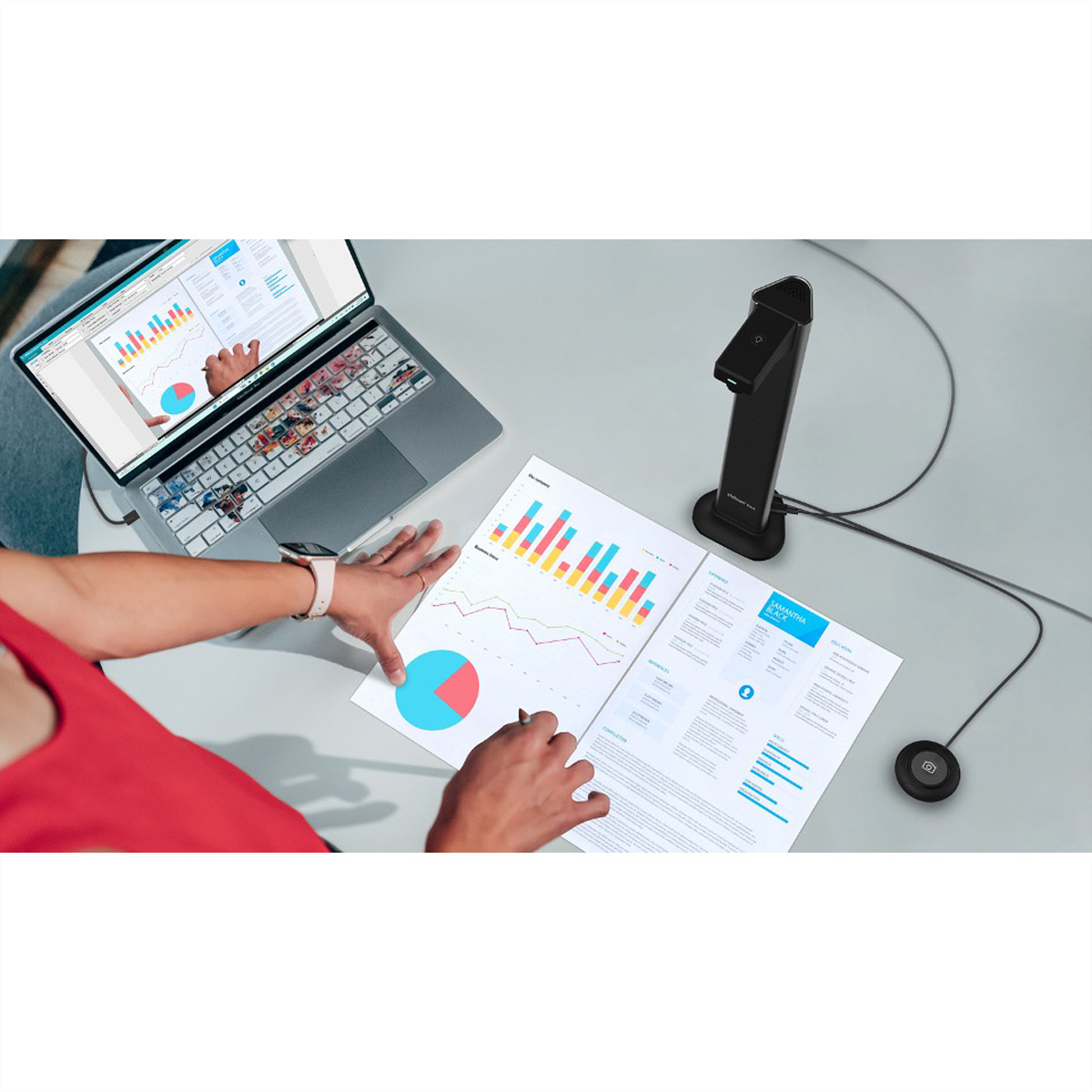 Personne à un bureau avec ordinateur portable, documents et scanner.