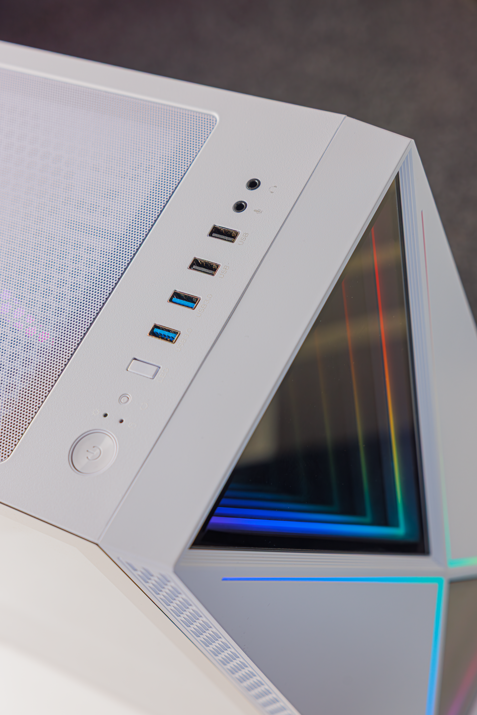 Ein weißes Computergehäuse mit USB-Anschlüssen, Netzschalter und RGB-Beleuchtung.