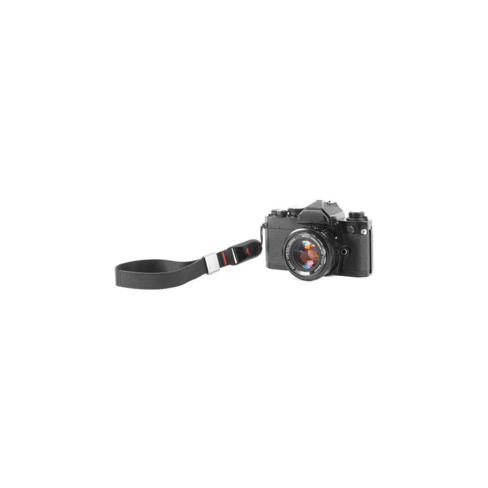 Een zwarte filmcamera met zwarte riem, op witte achtergrond.