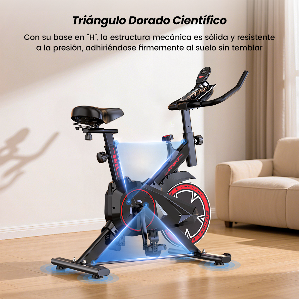 Bicicleta de spinning negra con base en H sobre suelo de madera, sofá cerca.