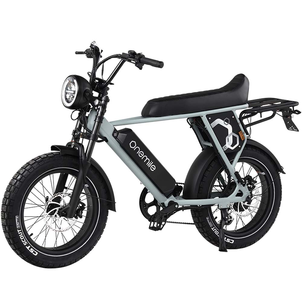 Una bicicleta eléctrica gris claro con asiento y neumáticos negros, con faro y portaequipajes.
