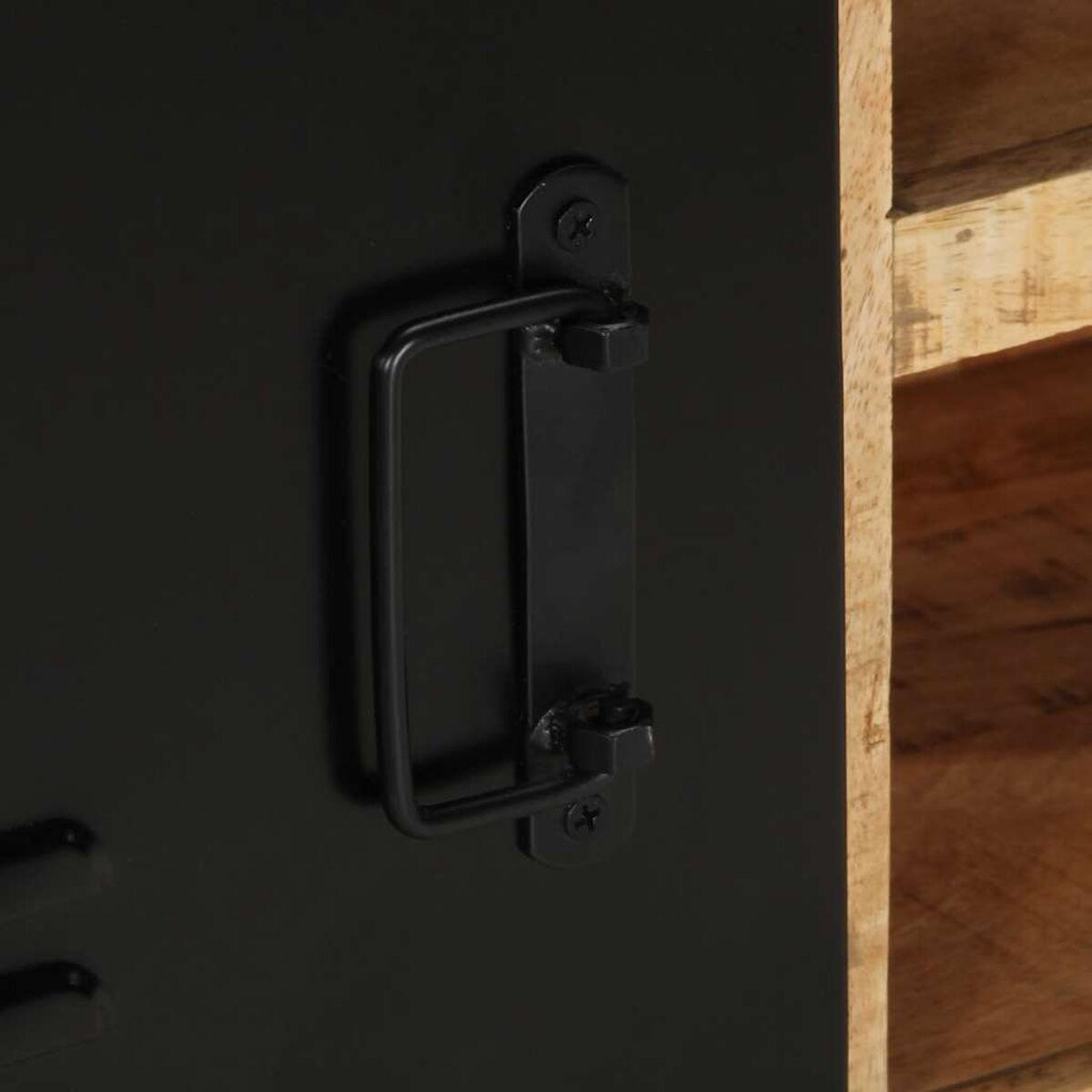 Un asa de metal negra está unida a una puerta negra. Se ve madera.