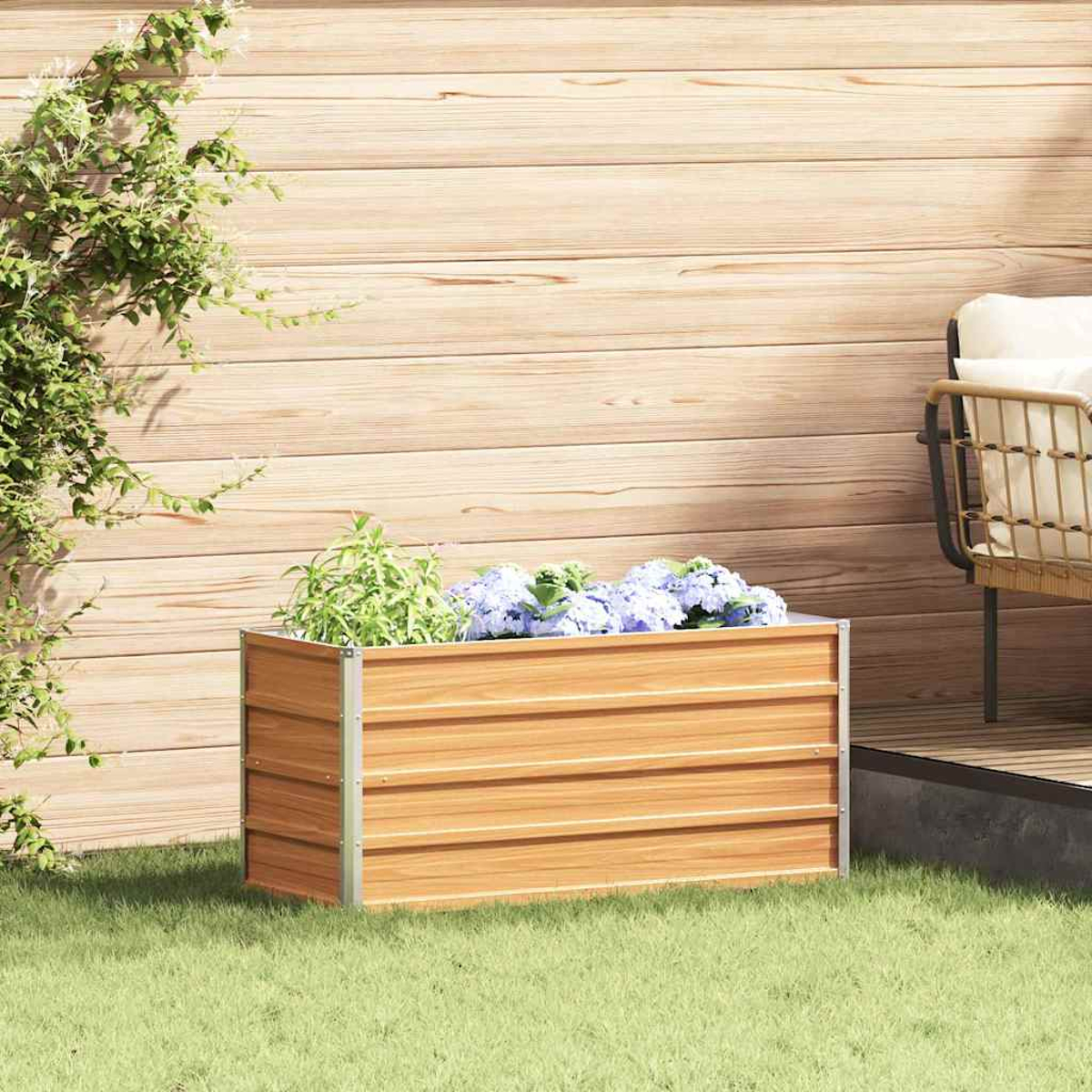 Una fioriera in legno con piante verdi e fiori blu sull'erba.