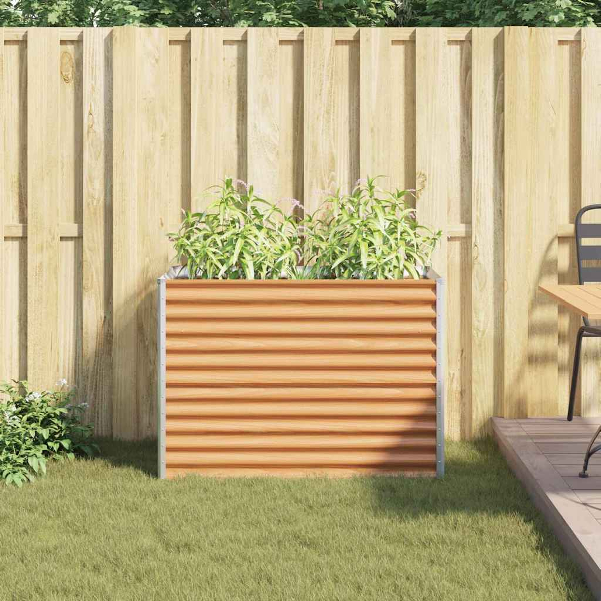 Un'aiuola rialzata rettangolare effetto legno si trova sull'erba verde davanti a una recinzione di legno.