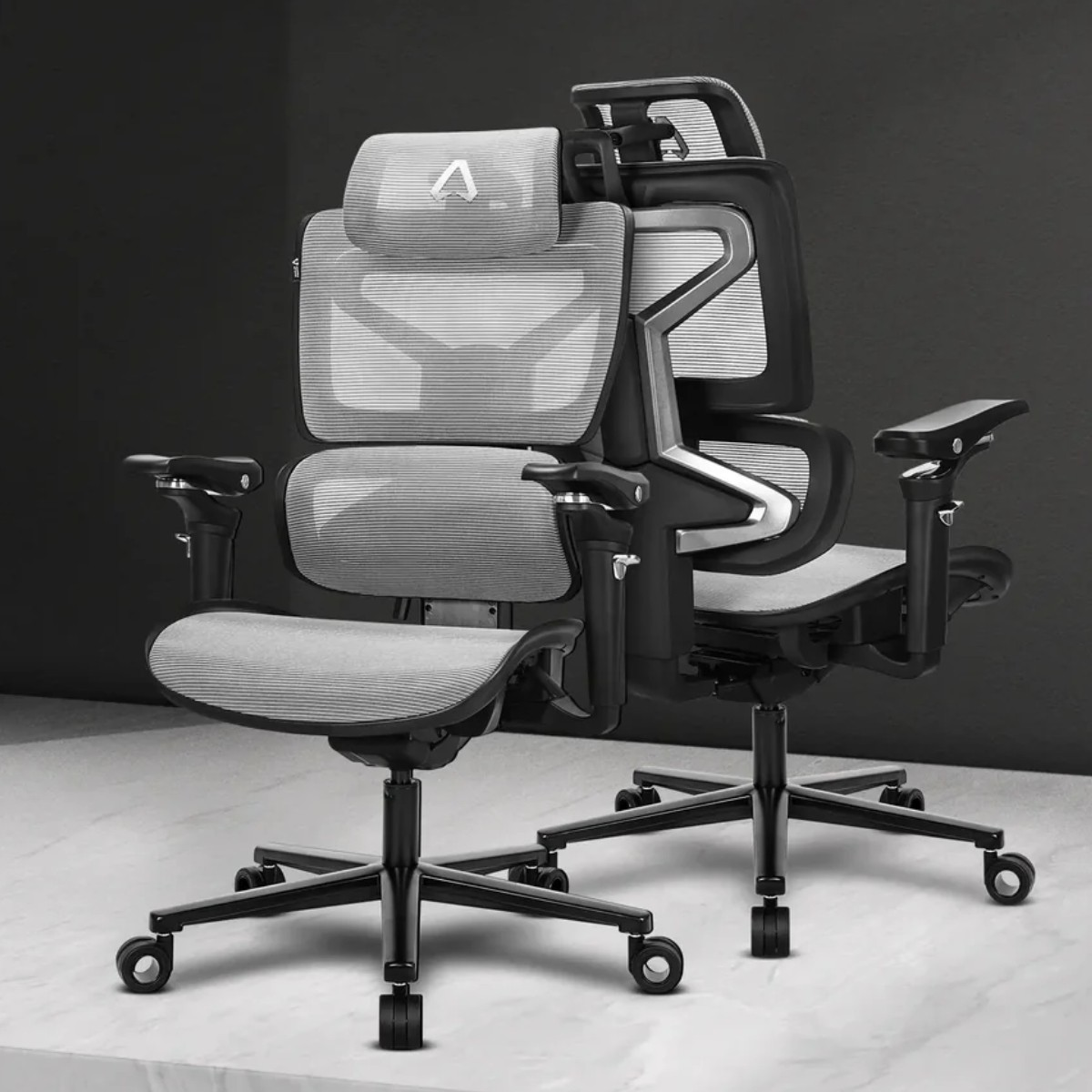 Due sedie ergonomiche moderne con sedili e schienali in rete grigia, su basi nere con ruote.