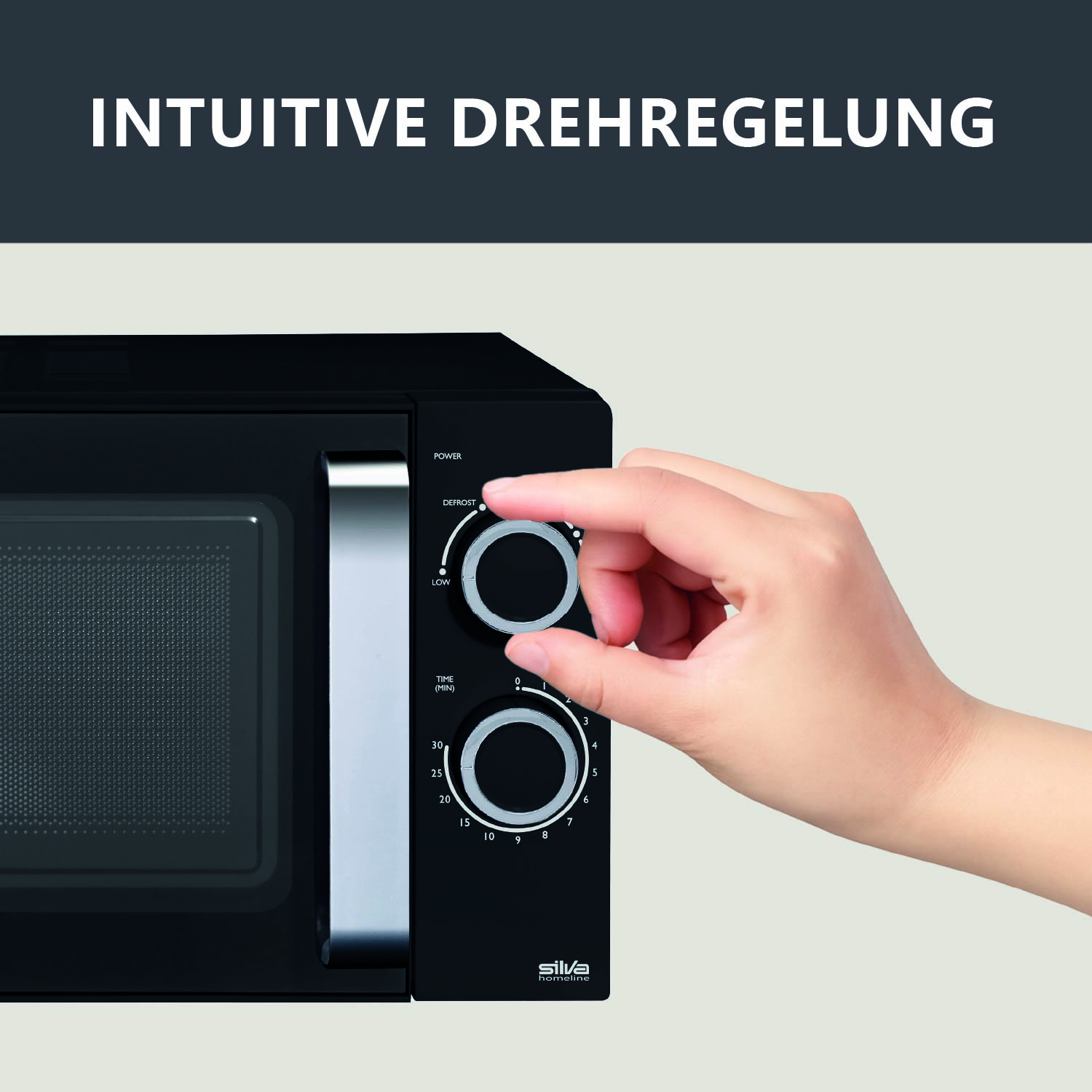 Eine Hand dreht einen Knopf an einer schwarzen Mikrowelle mit der Aufschrift INTUITIVE DREHREGELUNG.