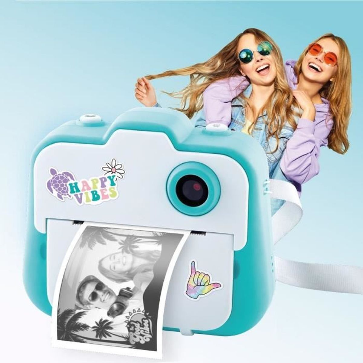 Due ragazze sorridenti dietro una fotocamera istantanea turchese che stampa una foto.