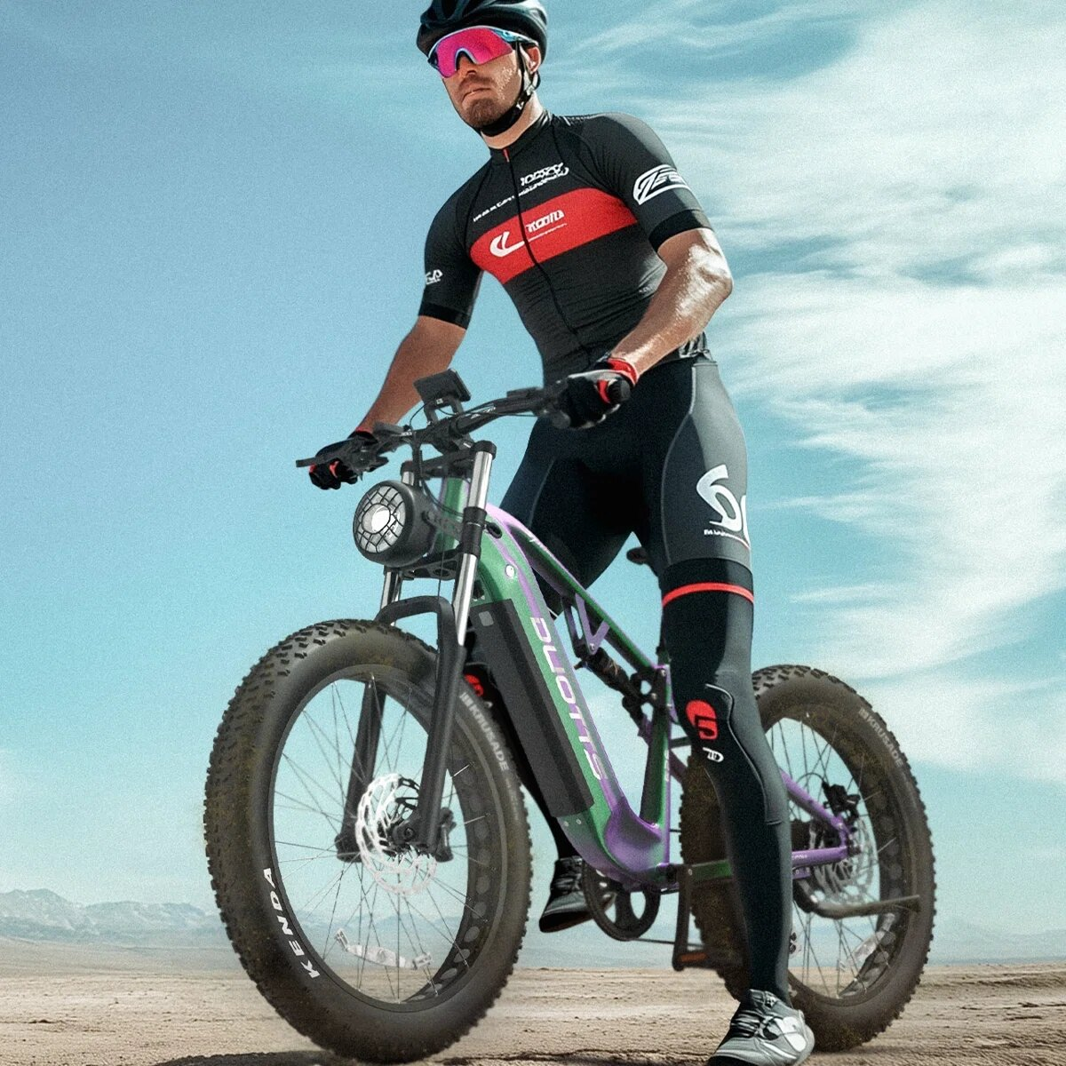 Mężczyzna w stroju kolarskim na zielono-fioletowym rowerze elektrycznym fat-bike.