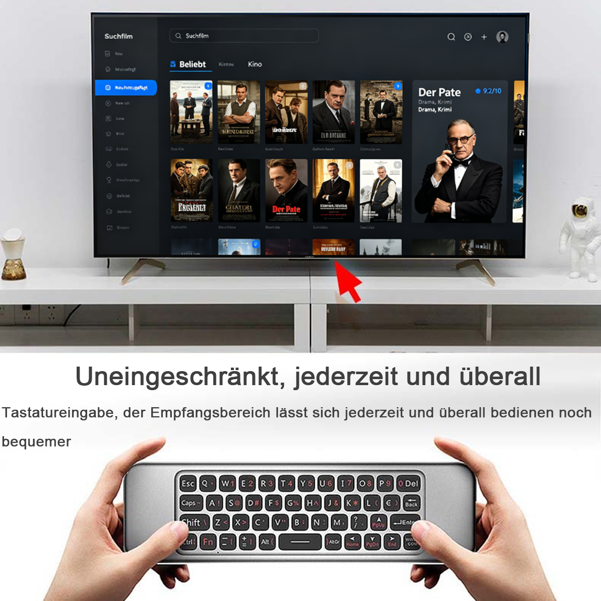 Ein Mann hält eine Mini-Tastatur, während ein Fernseher Filme anzeigt.