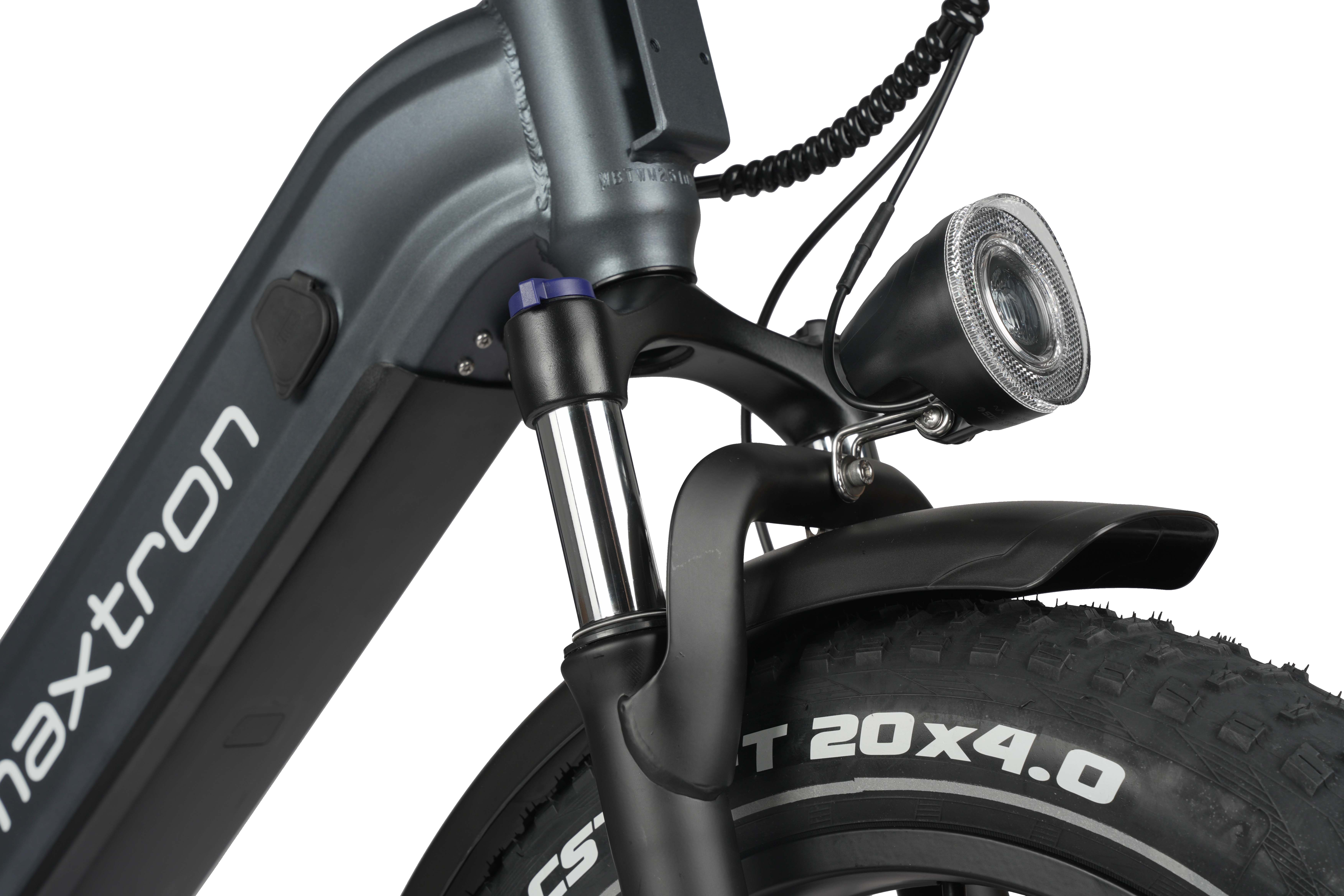 Parte anteriore e-bike grigia con faro, forcella ammortizzata e gomma larga.