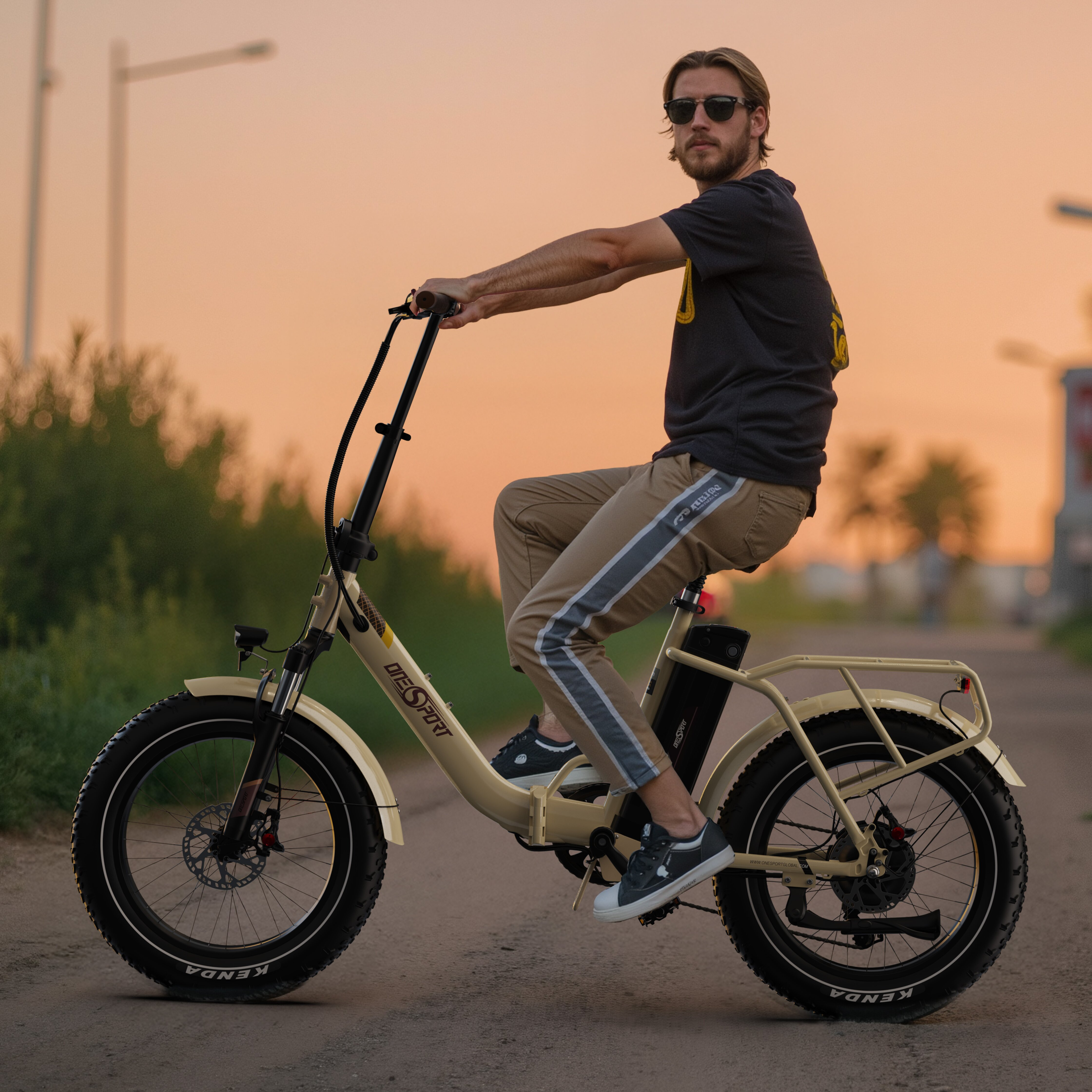 Uomo con occhiali da sole guida una e-bike color sabbia al tramonto.