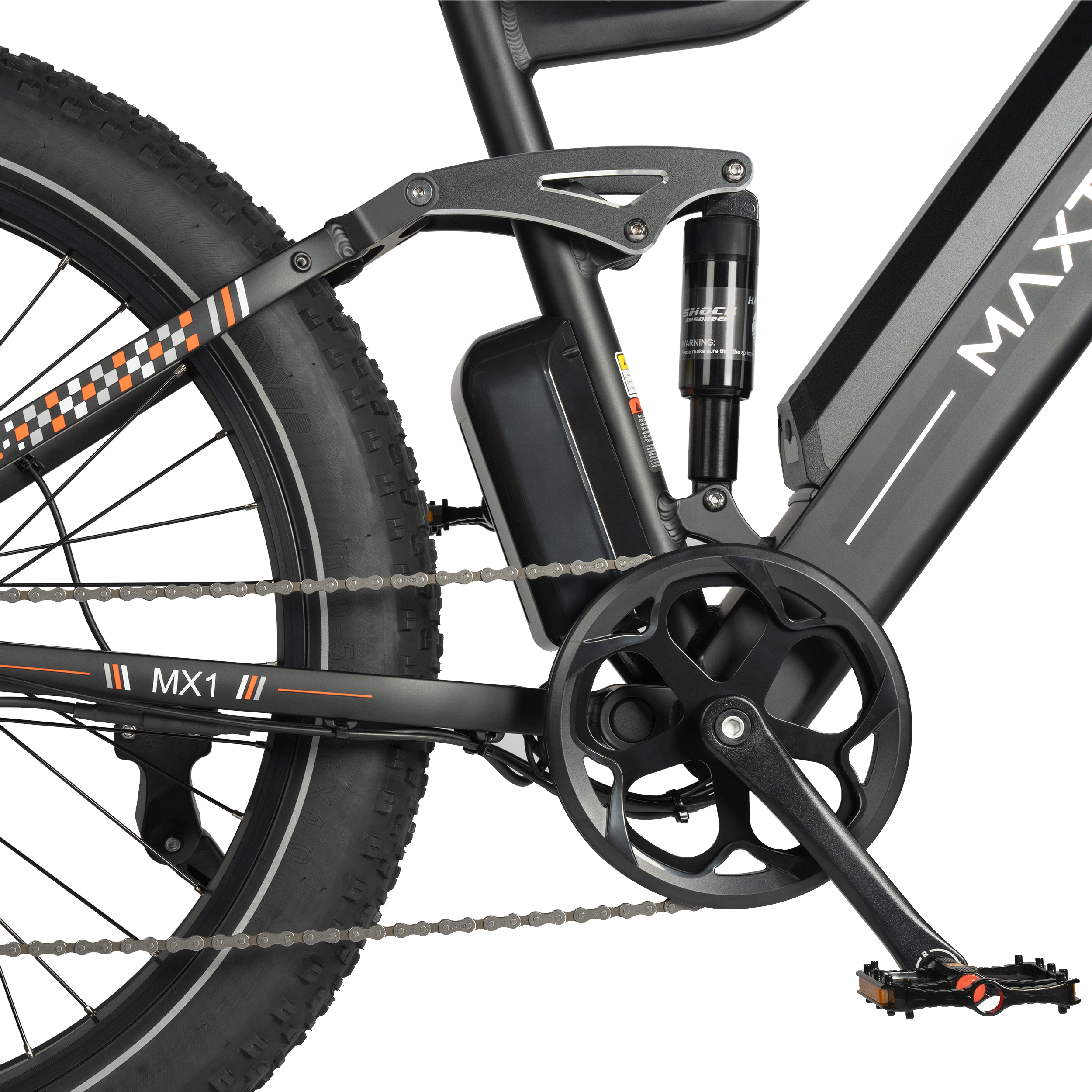 Primer plano de una bicicleta eléctrica negra con letras MX1, amortiguador y cadena.