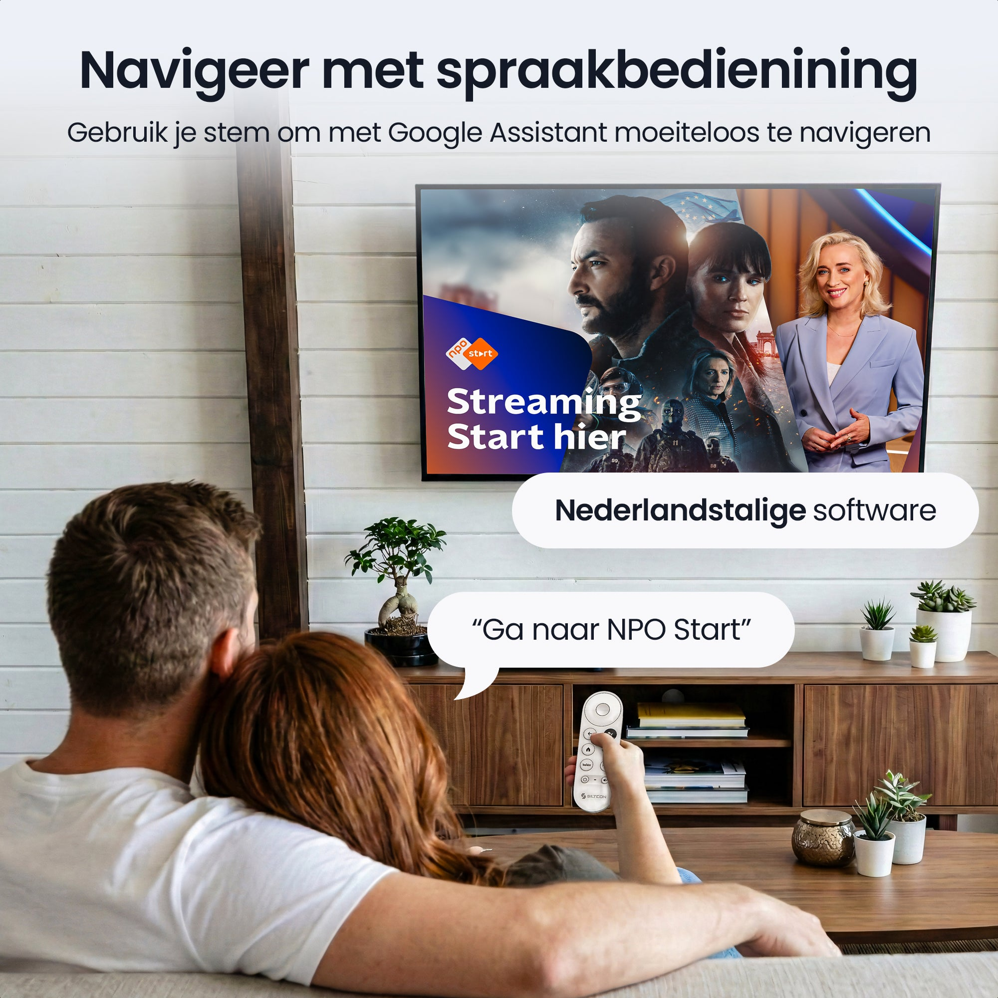 A couple on a sofa looks at a TV being navigated by voice commands.