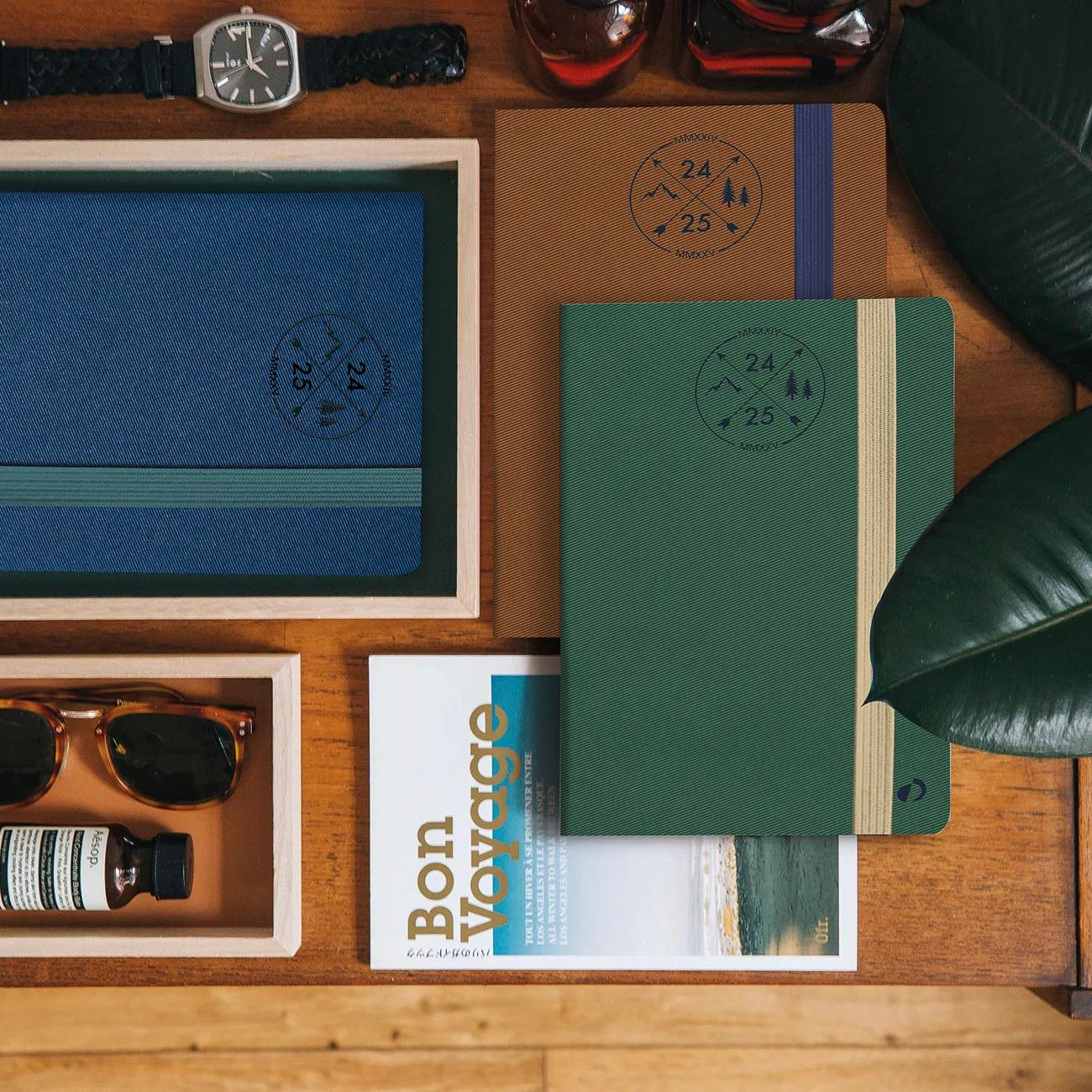 Una mesa con cuadernos, gafas de sol, un reloj y una revista.