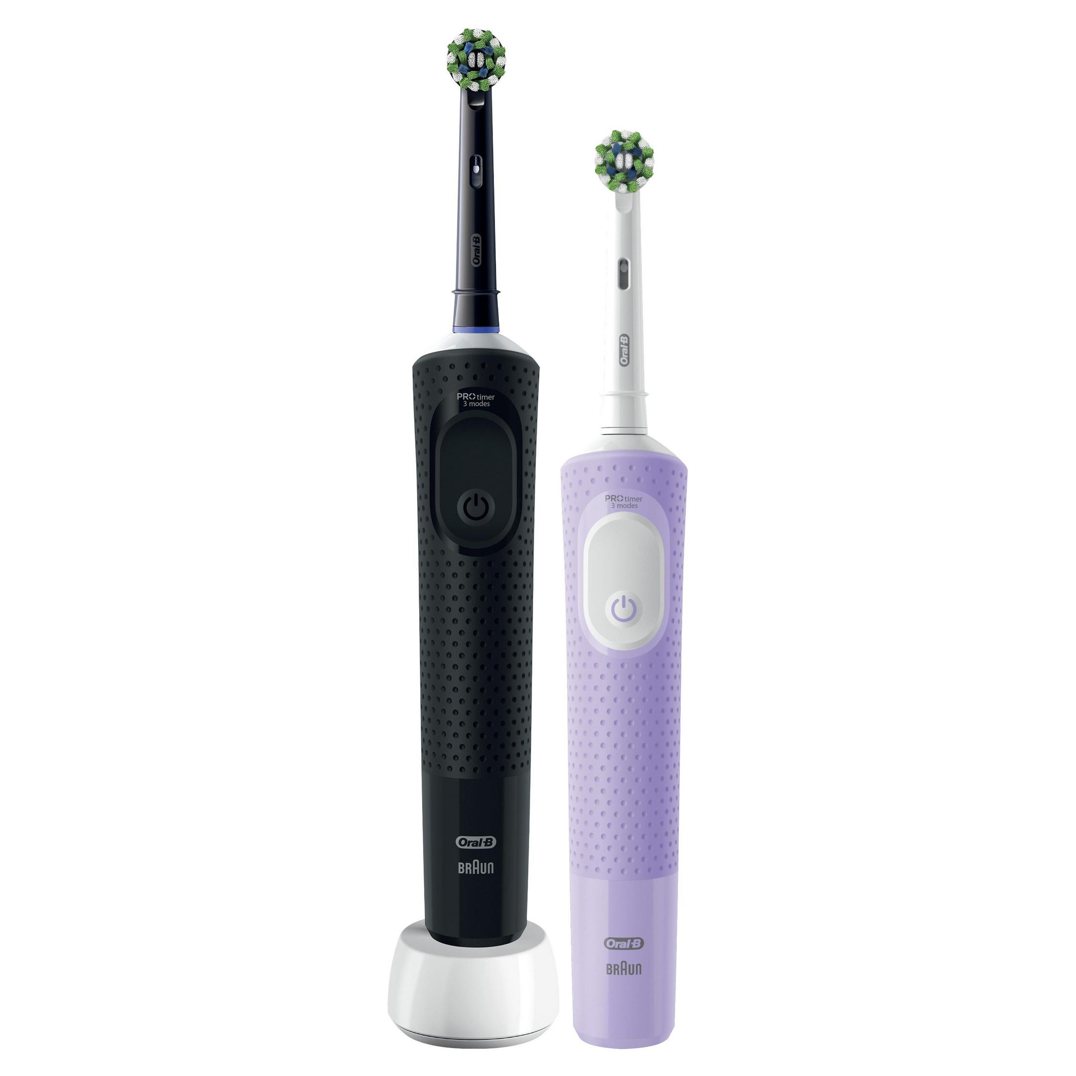 Dos cepillos de dientes eléctricos, negro y morado, con cabezales.