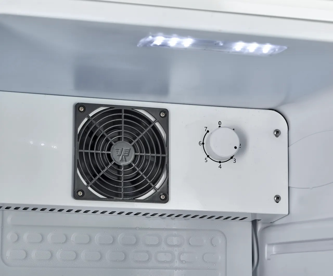 Ein Lüfter und ein Temperaturregler mit Skala von 0-7 in einem Kühlschrank.