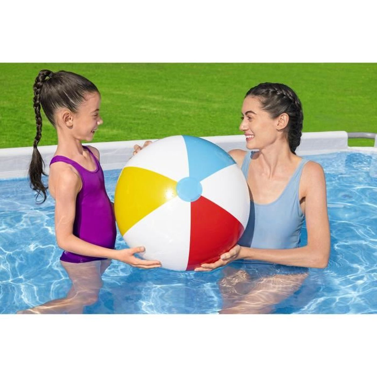 Zwei Mädchen in einem Pool halten einen bunten Ball.