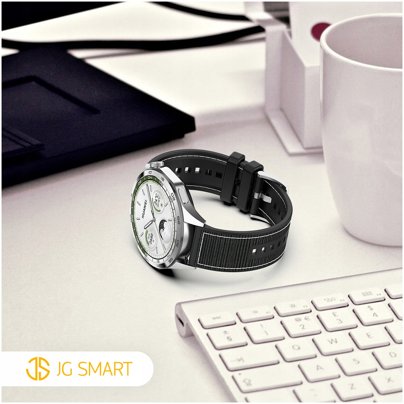 Zegarek smartwatch z czarnym paskiem leży na biurku obok klawiatury.