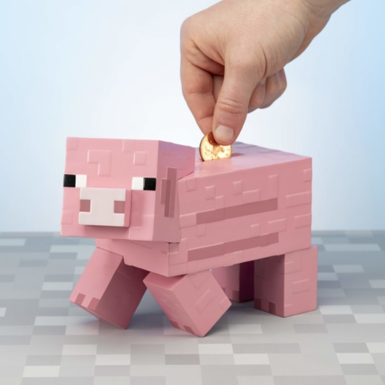 Ein rosafarbener Schweine-Sparschwein-Block wird von einer Hand gefüttert.