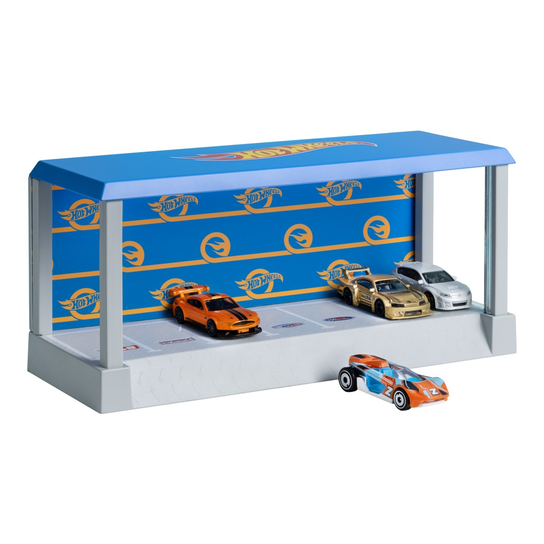 Garaż Hot Wheels z 5 samochodzikami: 2 pomarańczowe, 1 złoty, 1 srebrny, 1 niebiesko-pomarańczowy.