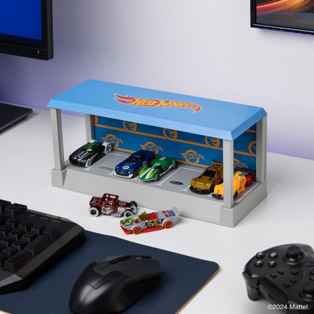 Zabawkowe samochody Hot Wheels w garażu z klawiaturą i myszką.