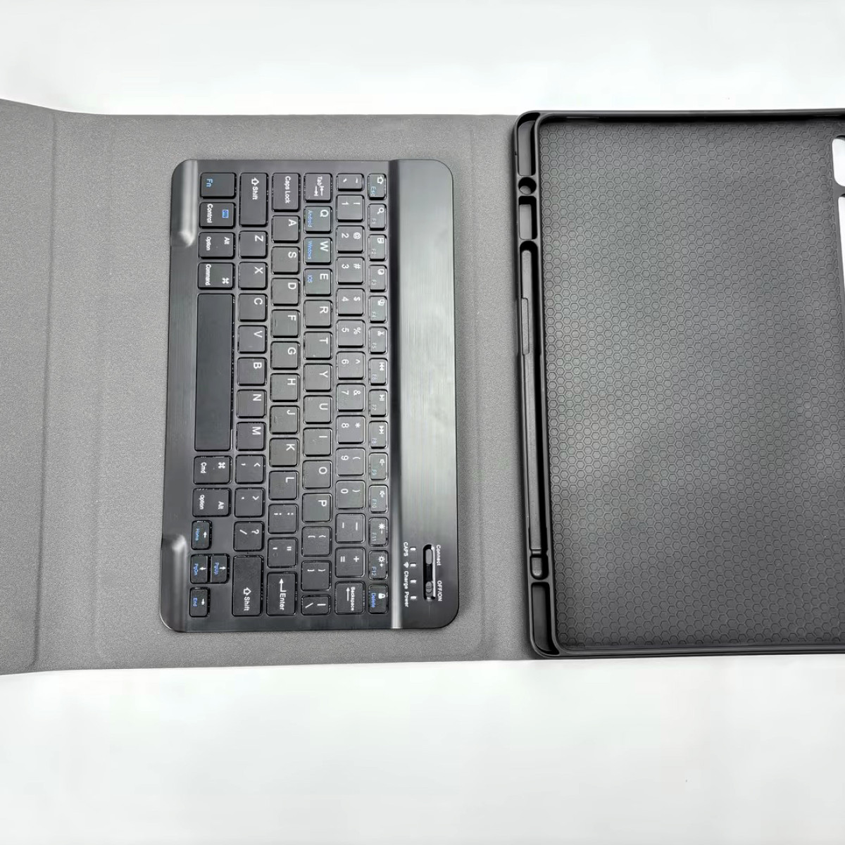 Czarna klawiatura i etui do tabletu leżą na białej powierzchni.