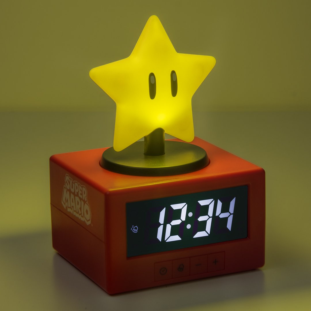 Czerwony budzik w kształcie sześcianu Super Mario ze świecącą żółtą gwiazdą i cyfrowym wyświetlaczem.