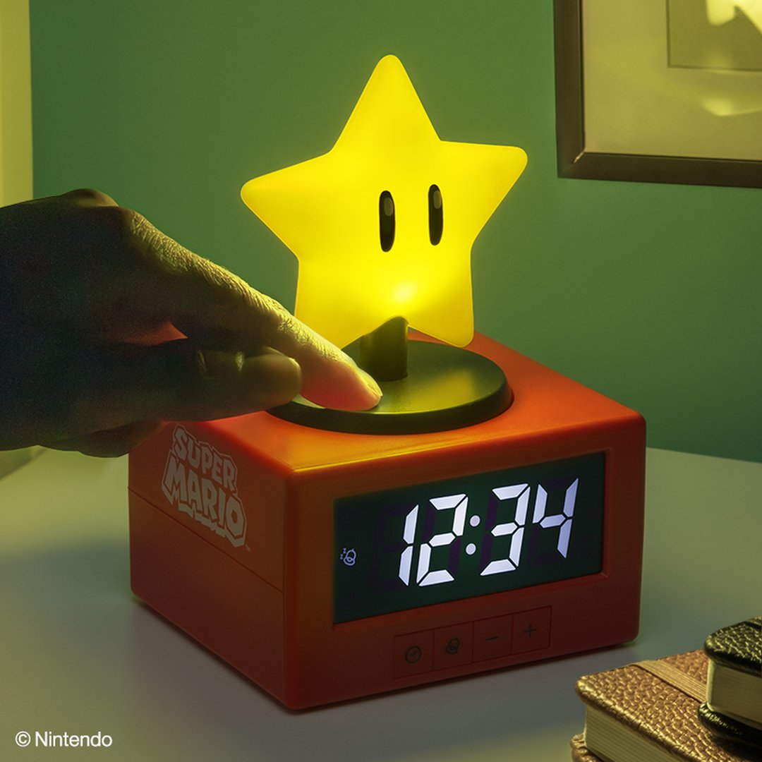 Zegar Super Mario ze świecącą gwiazdą. Ręka naciska przycisk.