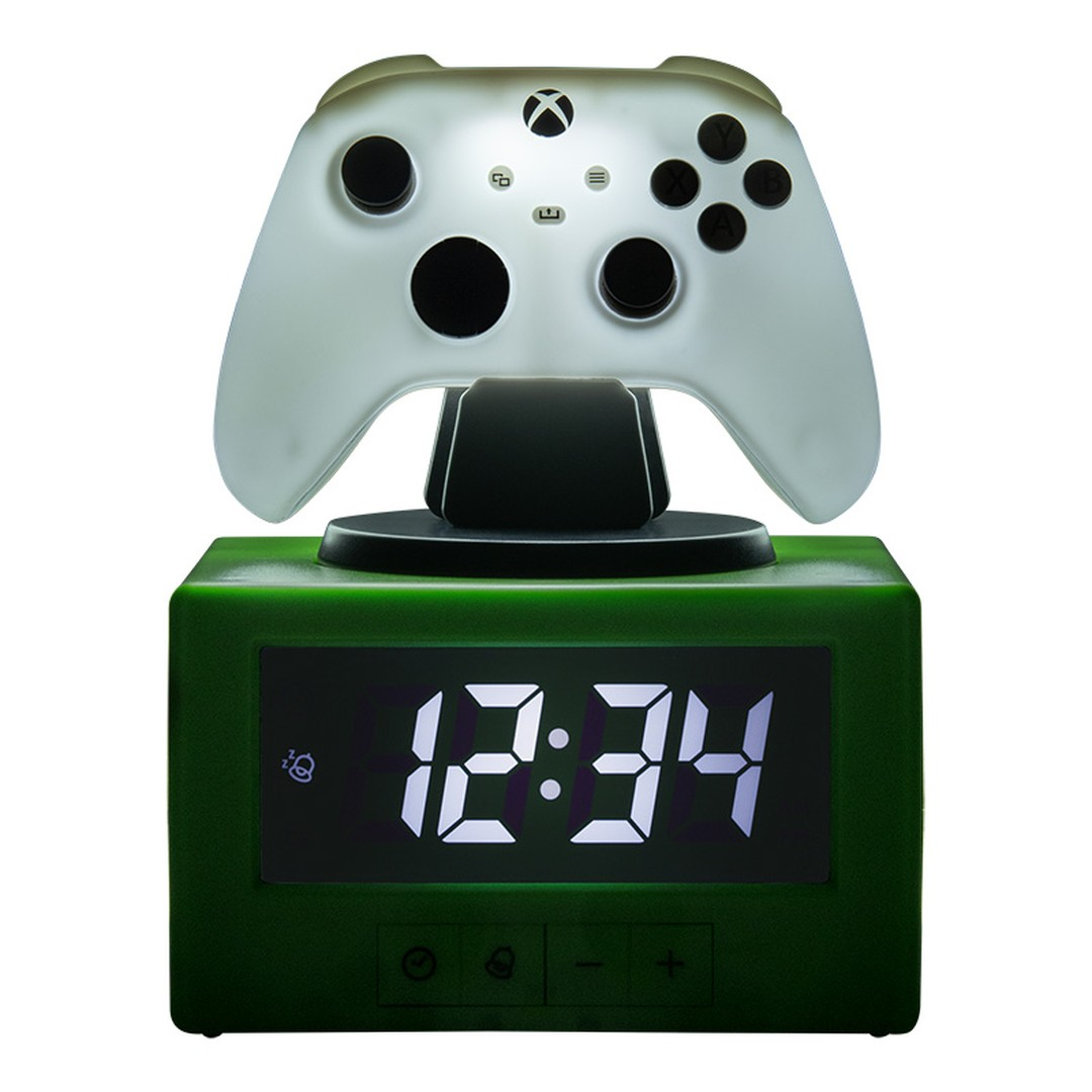 Zielony budzik w kształcie sześcianu z podświetlanym białym kontrolerem Xbox na górze.