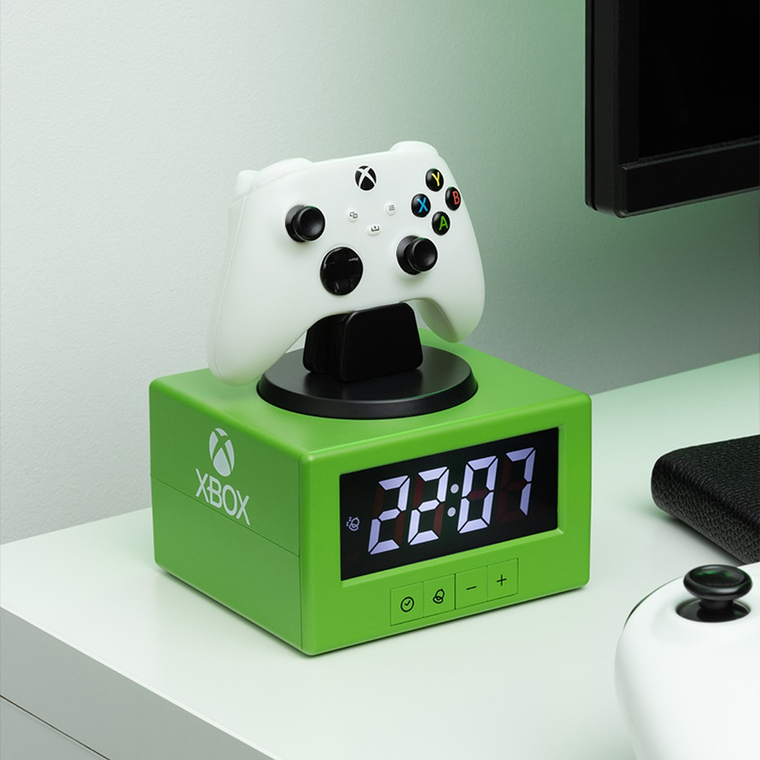 Zielony budzik Xbox z białym kontrolerem na górze. Godzina 22:07.